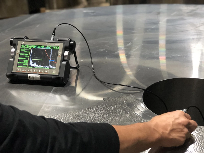 Ultrasonic Testing (UT) equipment scanning steel surface for internal defects